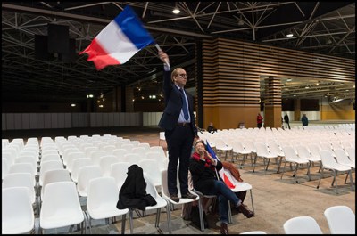 a supporter with a french flag. Francois Fillon, former French prime minister and candidate for the right-wing Les Republicains (The Republicans - LR) primaries ahead of the 2017 presidential delivers a speech during a meeting. Lyon, FRANCE-22/11/2016